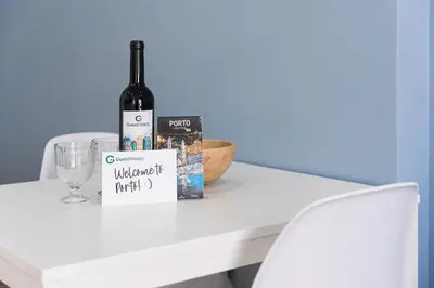 a bottle of wine and a glass on a white table at GuestReady - The Other Side in Porto