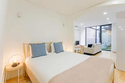 a bedroom with a large white bed with blue pillows at Casinha da Formosa by Oporto Soul in Porto