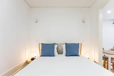 a bedroom with a large bed with blue pillows at Casinha da Formosa by Oporto Soul in Porto