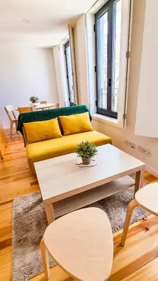 a living room with a yellow couch and a table at Jardim do Morro Haus in Vila Nova de Gaia