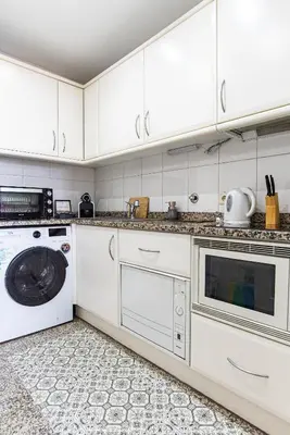 a kitchen with white cabinets and a washer and dryer at River 9 and City View Porto Gaia by MP in Vila Nova de Gaia