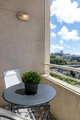 a table and a chair on a balcony with a plant at River 9 and City View Porto Gaia by MP in Vila Nova de Gaia