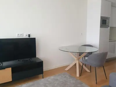 a living room with a table and a tv and a chair at Oporto Golden Flat in Porto
