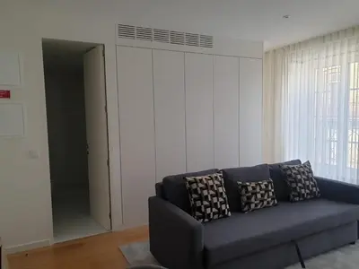 a living room with a blue couch and a window at Oporto Golden Flat in Porto