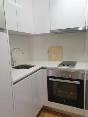 a kitchen with white cabinets and a stove and a sink at Oporto Golden Flat in Porto