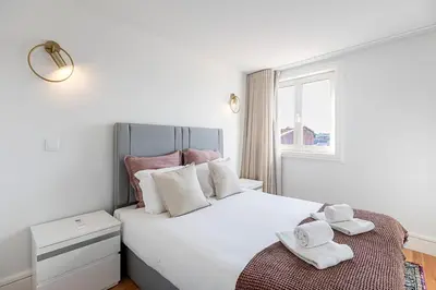 a bedroom with a large white bed with towels on it at Modern Cativo Apartment by LovelyStay in Porto