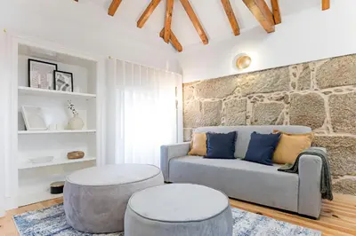 a living room with a couch and two stools at Modern Cativo Apartment by LovelyStay in Porto