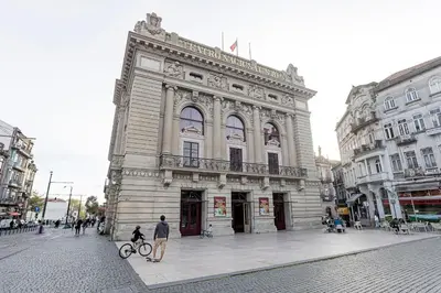 an old building on a city street with a man on a bike at Modern Cativo Apartment by LovelyStay in Porto