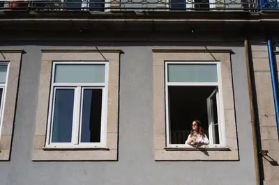 a woman is looking out of a window at Bicycle Luxury House, parking, downtown near metro in Porto