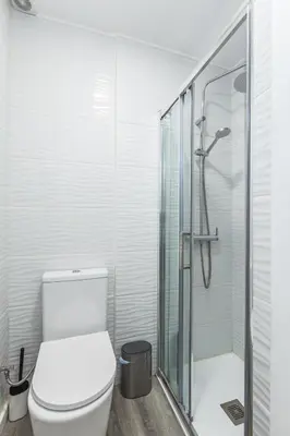 a bathroom with a toilet and a glass shower at Casa do Barqueiro - Porto in Porto