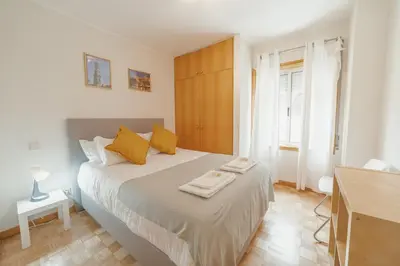 a bedroom with a large bed with yellow pillows at Downtown Trindade Apartment With Terrace by Vacationy in Porto