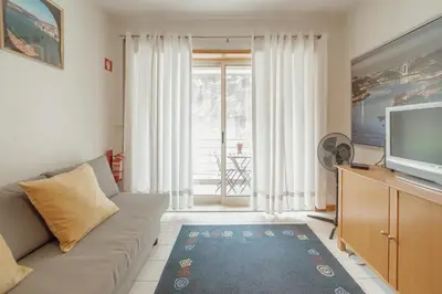 a living room with a couch and a television at Downtown Trindade Apartment With Terrace by Vacationy in Porto
