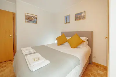 a bedroom with a white bed with yellow pillows at Downtown Trindade Apartment With Terrace by Vacationy in Porto