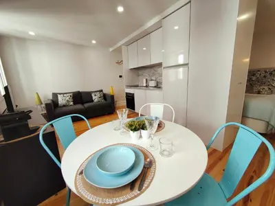 a white table with blue chairs in a living room at Cristelo 2 - near the river Porto in Porto