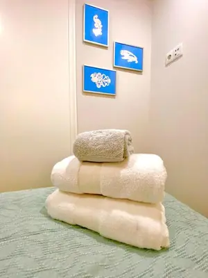 a stack of towels sitting on top of a bed at Cristelo 2 - near the river Porto in Porto