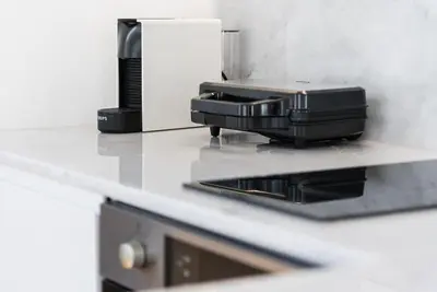 a black appliance sitting on a counter in a kitchen at Cedofeita Balcony with Free Parking in Porto