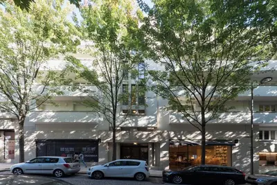 a white building with cars parked in front of it at Luxury City Center Emporium in Porto