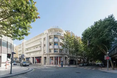 a large white building on a city street at Luxury City Center Emporium in Porto