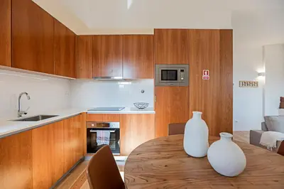 two white vases sitting on a wooden table in a kitchen at Wonderful Flat Near River w/ AC by LovelyStay in Porto