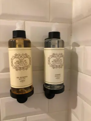 two bottles of shampoo are sitting in a wall at Central charming apartment in Porto