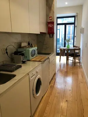 a kitchen with a washing machine and a sink at Central charming apartment in Porto