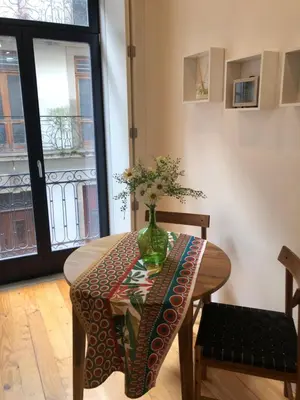a table with a vase of flowers on it at Central charming apartment in Porto