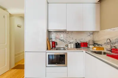 a white kitchen with white cabinets and a sink at Oporto Viva la Vida Central apartment in Porto