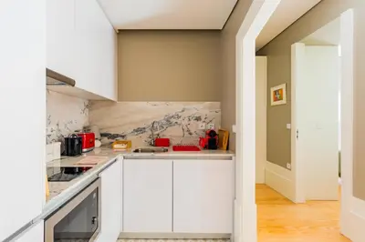 a kitchen with white cabinets and a wall at Oporto Viva la Vida Central apartment in Porto