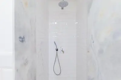 a shower with a shower head in a white bathroom at Oporto Viva la Vida Central apartment in Porto