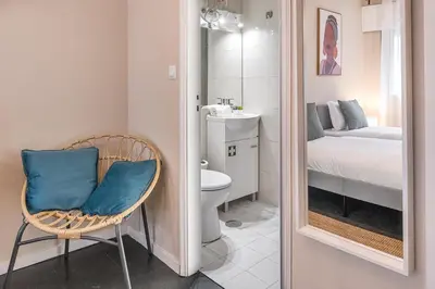 a bathroom with a mirror and a chair in a room at GuestReady - OPortoGrow Central Batalha 2 in Porto