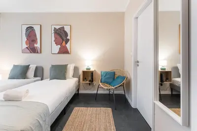 a small room with two beds and a chair at GuestReady - OPortoGrow Central Batalha 2 in Porto