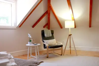 a living room with a chair and a lamp at A Window to Porto - Fabulous apartment by Douro River in Porto