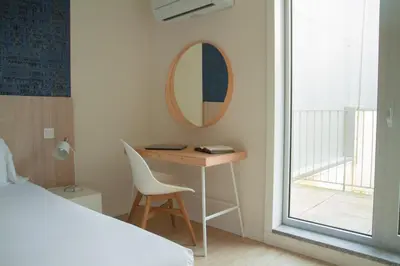a bedroom with a desk and a mirror and a bed at room Select Porto Suites in Porto