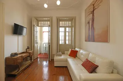 a living room with a white couch and a tv at FLH Porto Classic Apartment with Parking in Porto