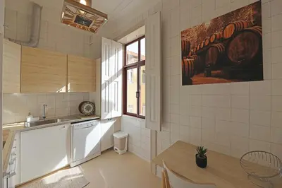 a kitchen with a sink and a table and a painting on the wall at FLH Porto Classic Apartment with Parking in Porto