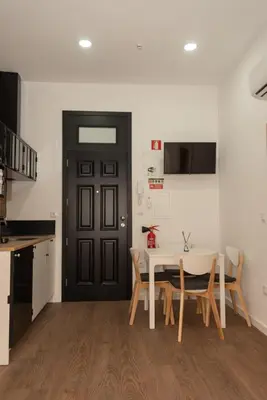 a dining room with a table and a black door at Fervença Great Stay Apartment in Vila Nova de Gaia