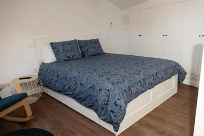 a bedroom with a bed with a blue comforter at Fervença Great Stay Apartment in Vila Nova de Gaia
