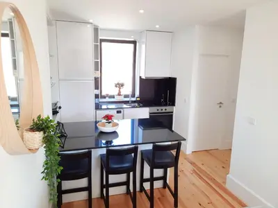 a kitchen with a black table and chairs at A Window to Porto St. Helena in Porto