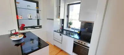 a kitchen with white cabinets and a black counter top at A Window to Porto St. Helena in Porto