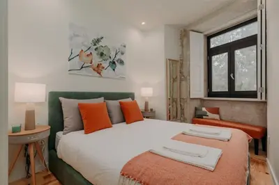 a bedroom with a large white bed with orange pillows at Swimming Pool Luxury House, with AC Downtown Porto in Porto