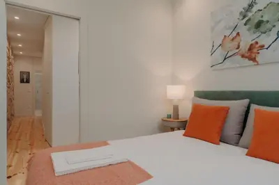 a bedroom with a white bed with orange pillows at Swimming Pool Luxury House, with AC Downtown Porto in Porto