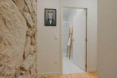 a hallway with a stone wall and a door with a picture at Swimming Pool Luxury House, with AC Downtown Porto in Porto