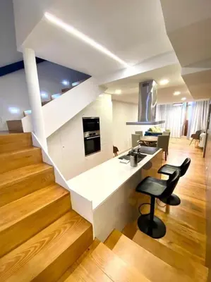 a kitchen with a sink and a counter with two stools at OHH-Padre Antonio Vieira Flat- HU in Porto
