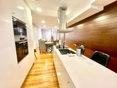 a kitchen with a white counter and a dining room at OHH-Padre Antonio Vieira Flat- HU in Porto