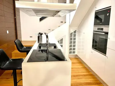 a kitchen with a sink and some black chairs at OHH-Padre Antonio Vieira Flat- HU in Porto