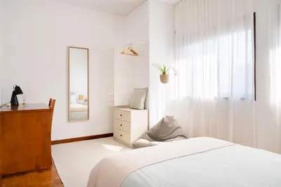 a white bedroom with a bed and a mirror at ! Bright 2BR Hammock Flat ! Praça da República in Porto