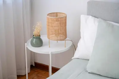 a table with a vase on it next to a bed at ! Bright 2BR Hammock Flat ! Praça da República in Porto