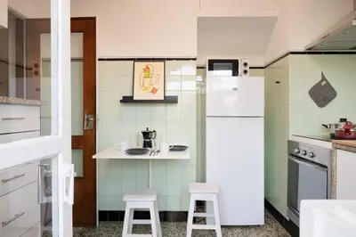 a kitchen with a white refrigerator and two stools at ! Bright 2BR Hammock Flat ! Praça da República in Porto