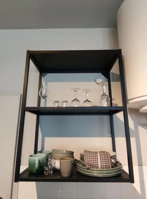 a shelf with dishes and glasses on it in a kitchen at Oporto Batalha Nice View Flat in Porto