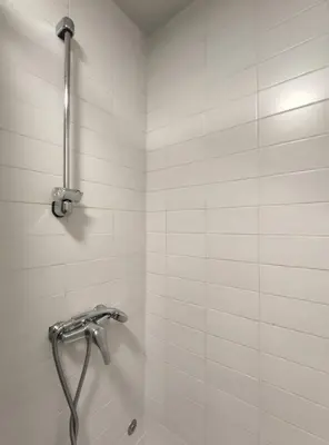a shower in a bathroom with white tiles at Oporto Batalha Nice View Flat in Porto